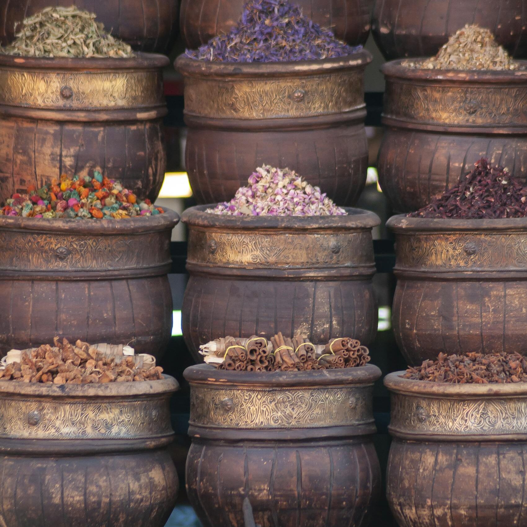 Traditional wooden pots with assorted colorful dried herbs and condiments in local bazaar in daytime